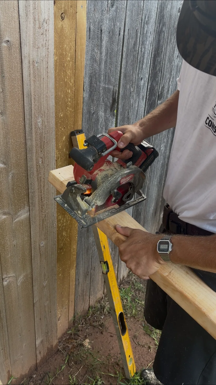 Geaux Cajun crew member cutting fence boards